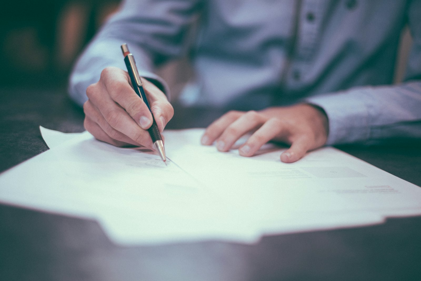 Homeowner signing rebate application paperwork at a desk
