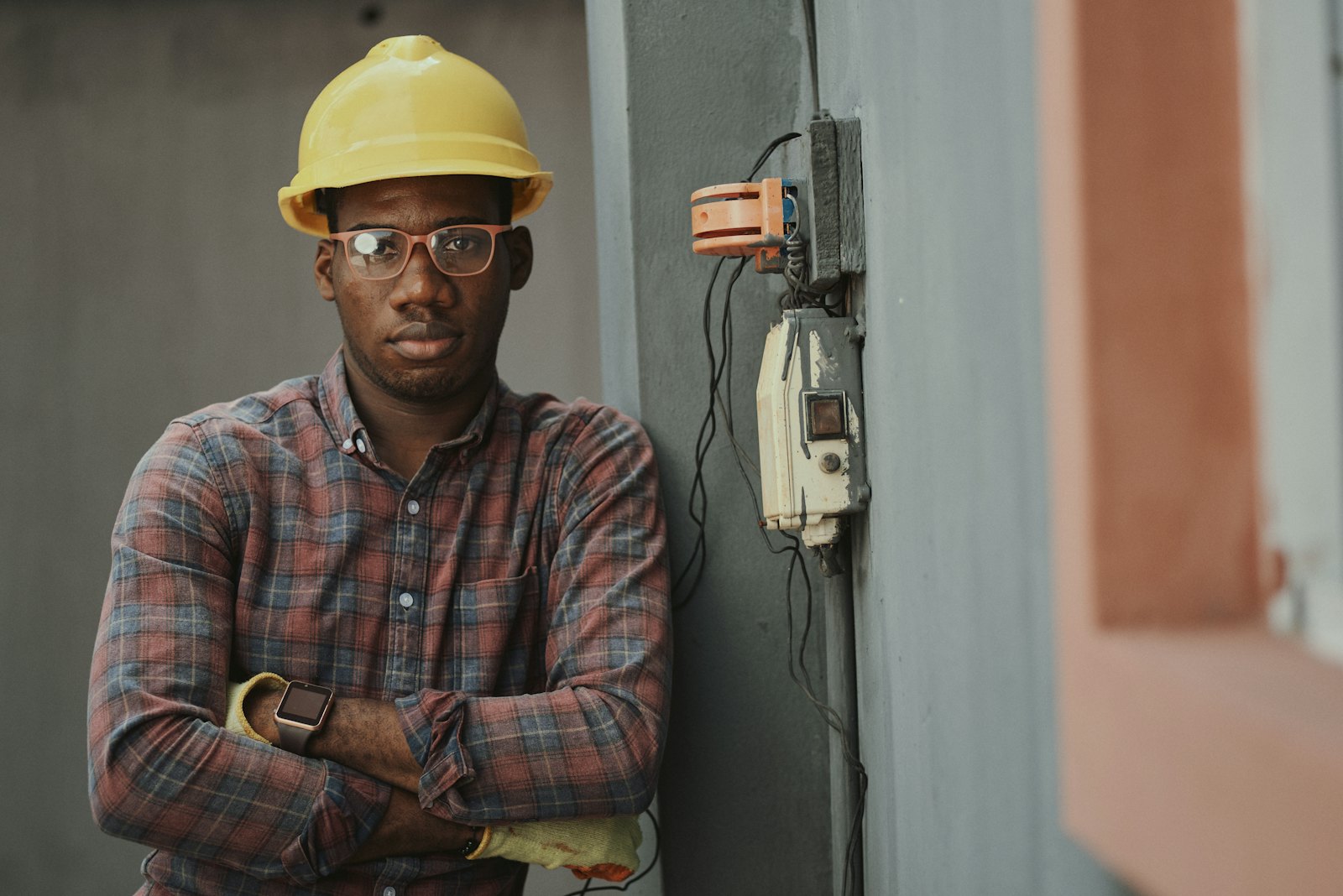 Licensed electrician standing next to exterior service wiring and meter equipment