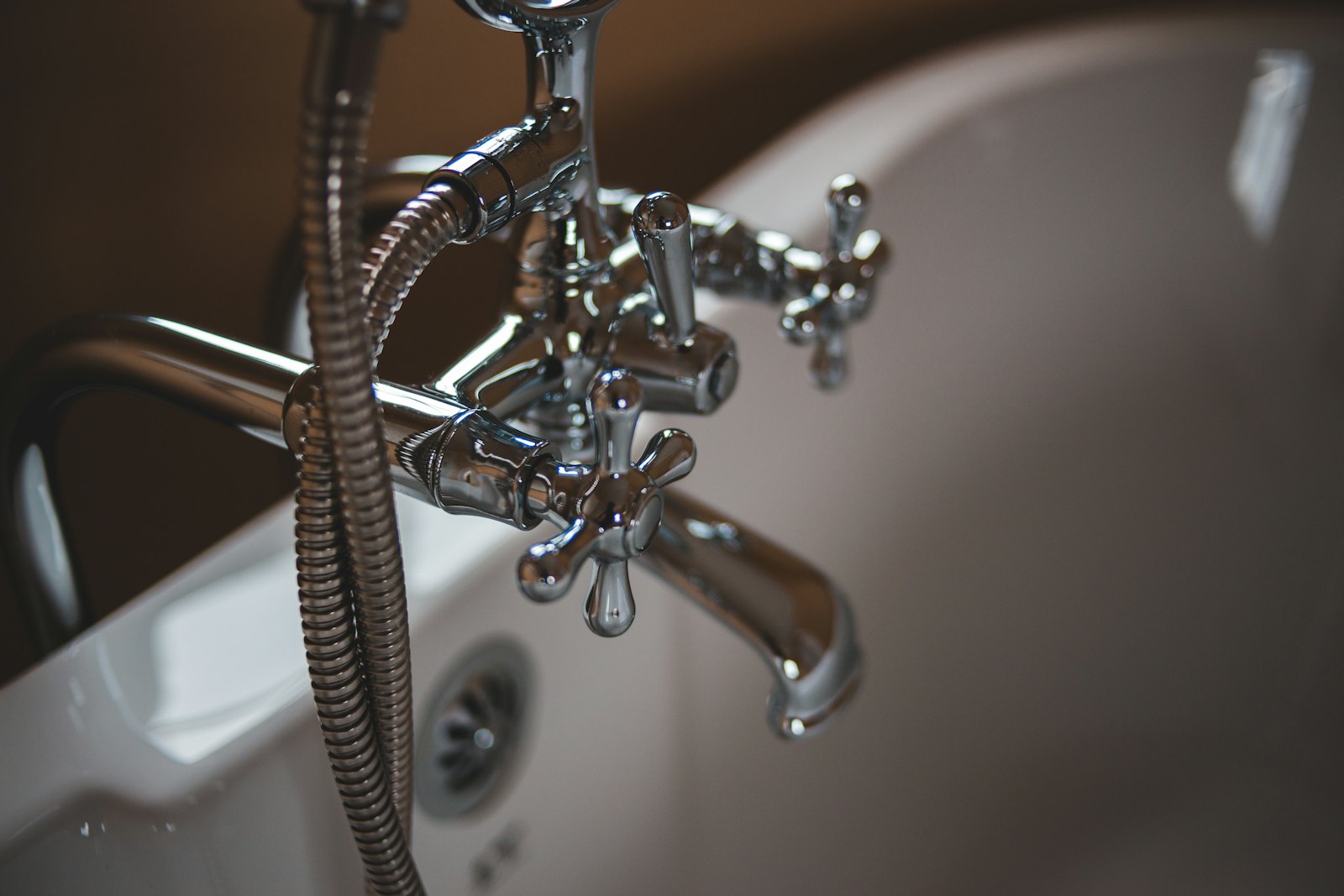 Chrome hot-water fixtures on a residential bathtub supplied by an efficient water heater